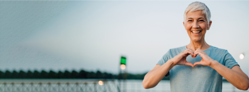 Smiling woman making a heart with her hands, representing bioidentical hormone therapy at Alternative Wellness Clinic